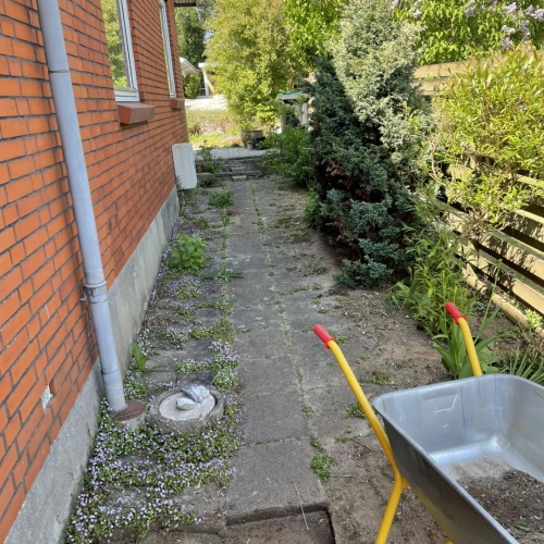 Indkørsel og terrasseområde med ny belægning under udførelse ved moderne bolig.