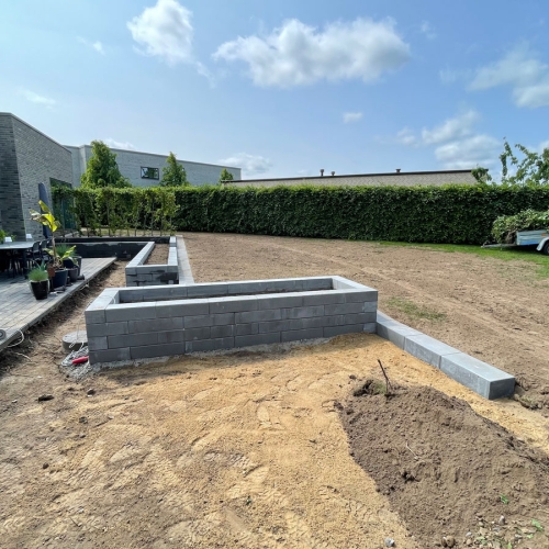 Ny støttemur og hævet plantebed etableret langs terrasse i moderne have.